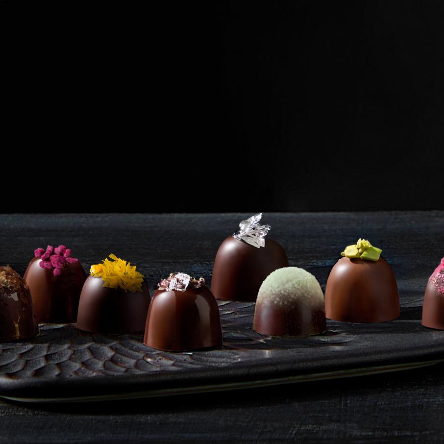Assorted Dark Chocolate and Milk Chocolate Truffles beautifully displayed on a dark slate platter.