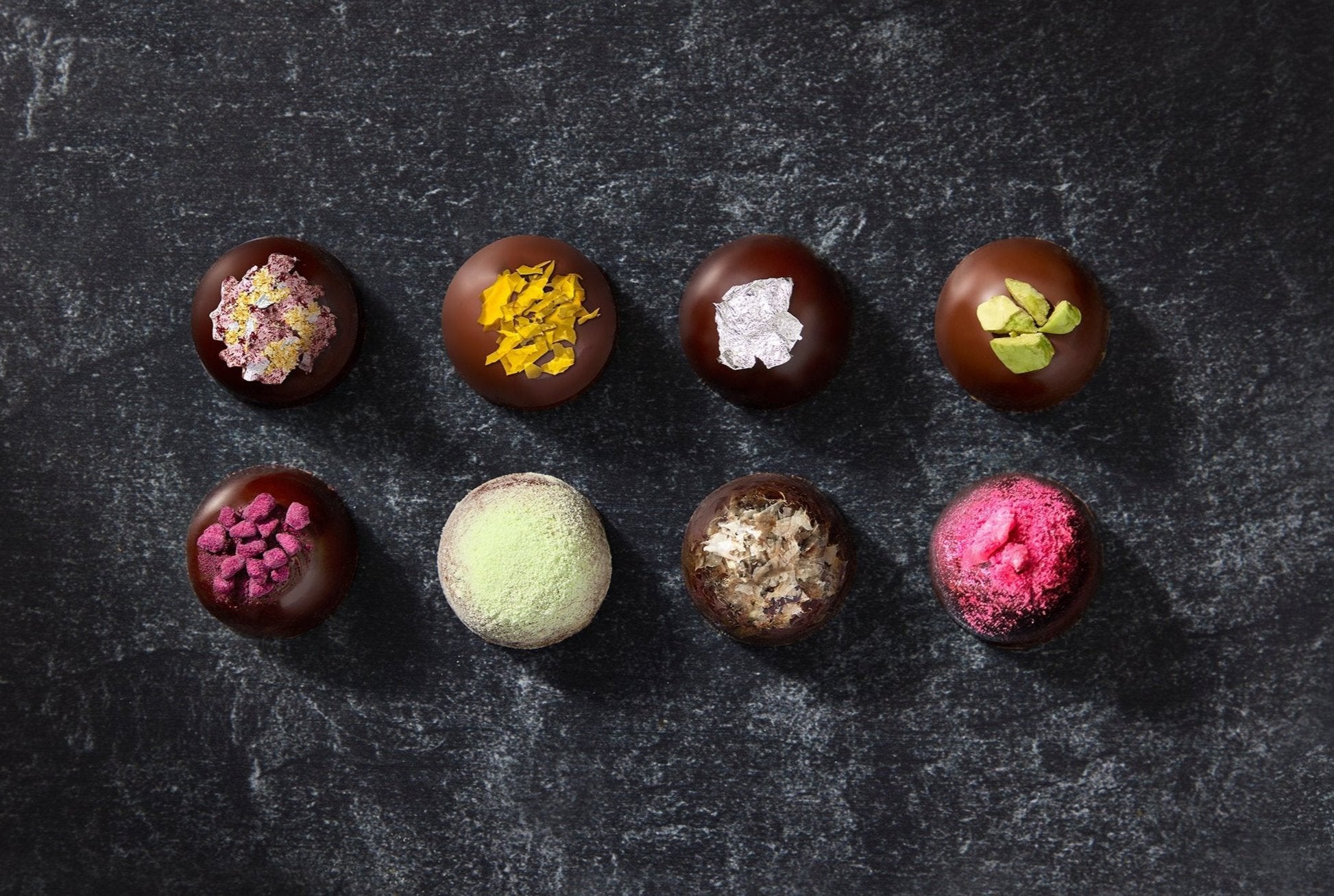 Assortment of Dark Chocolate and Milk Chocolate Truffles on a dark slate platter