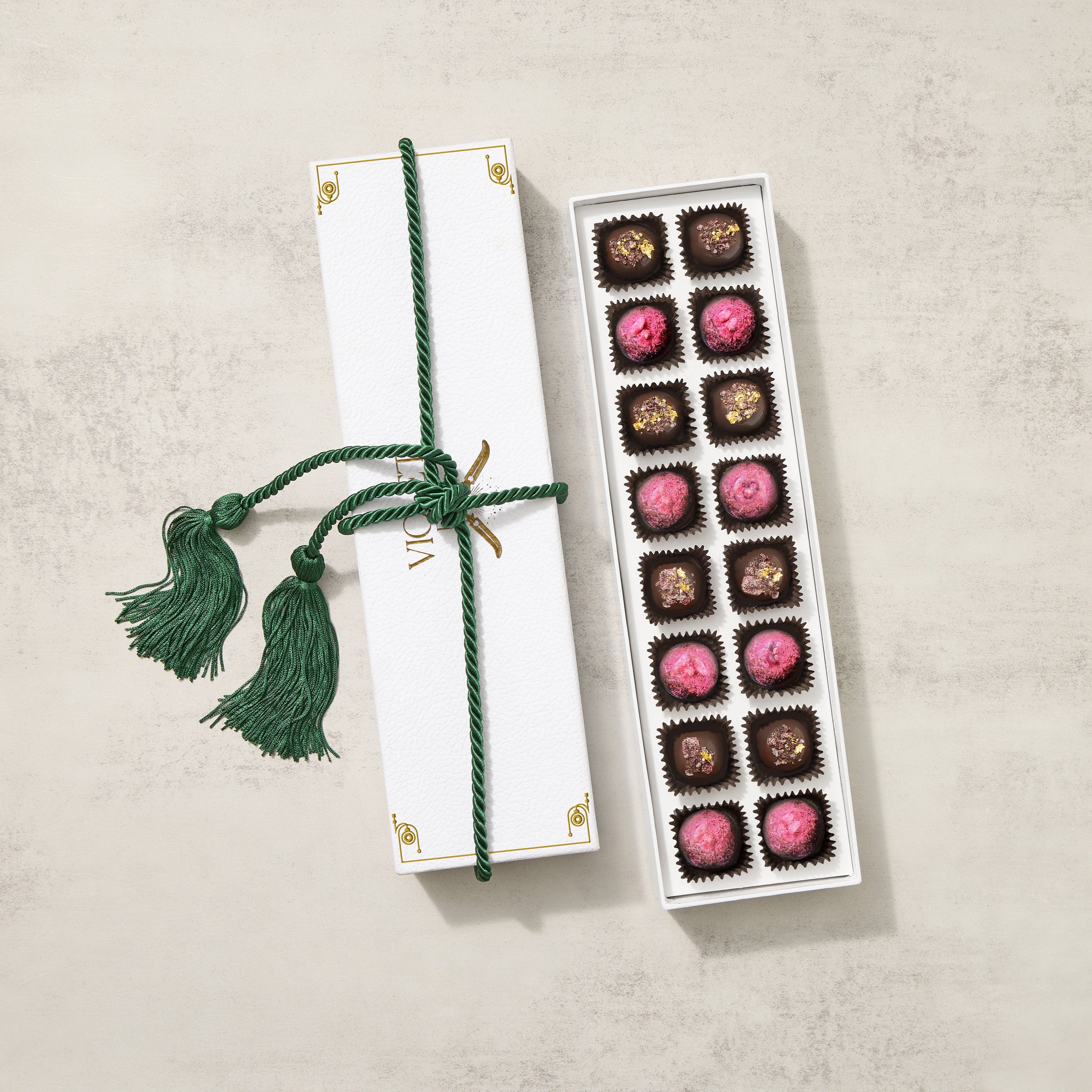 Beautiful white gift box featuring chocolate truffles in both milk chocolate and dark chocolate. Box is tied with a green tassel
