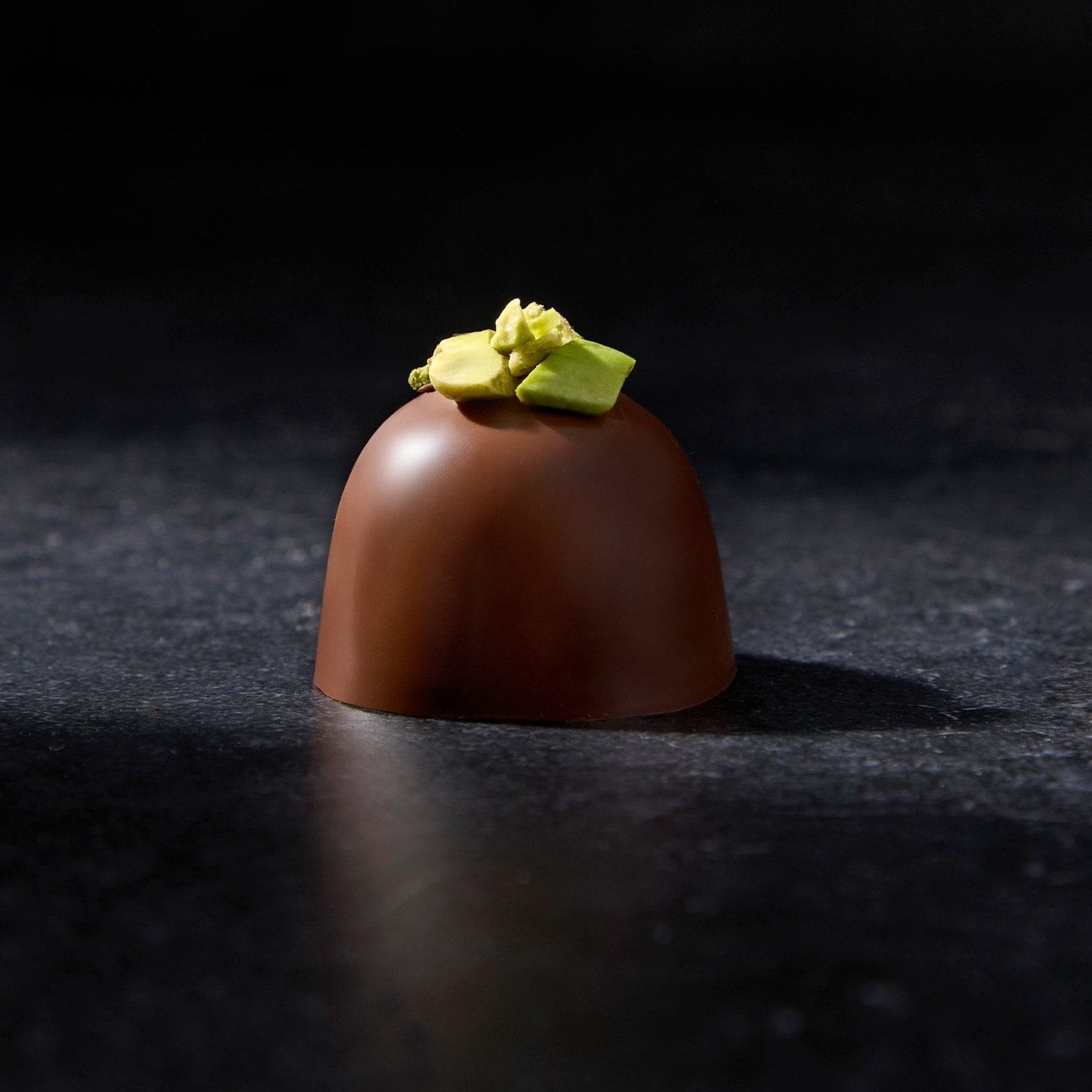 Milk Chocolate Truffle with bright green bronte pistachios sprinkled on top