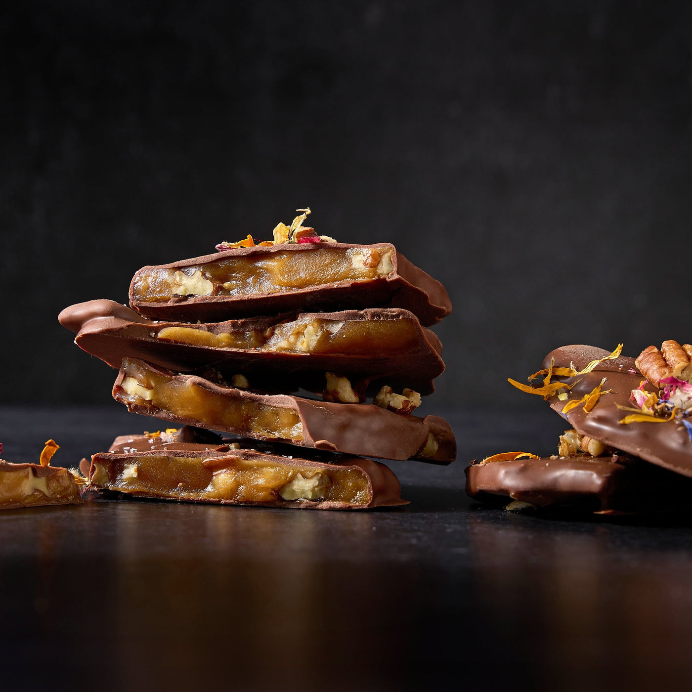 a stack of chocolate bars with nuts and candies
