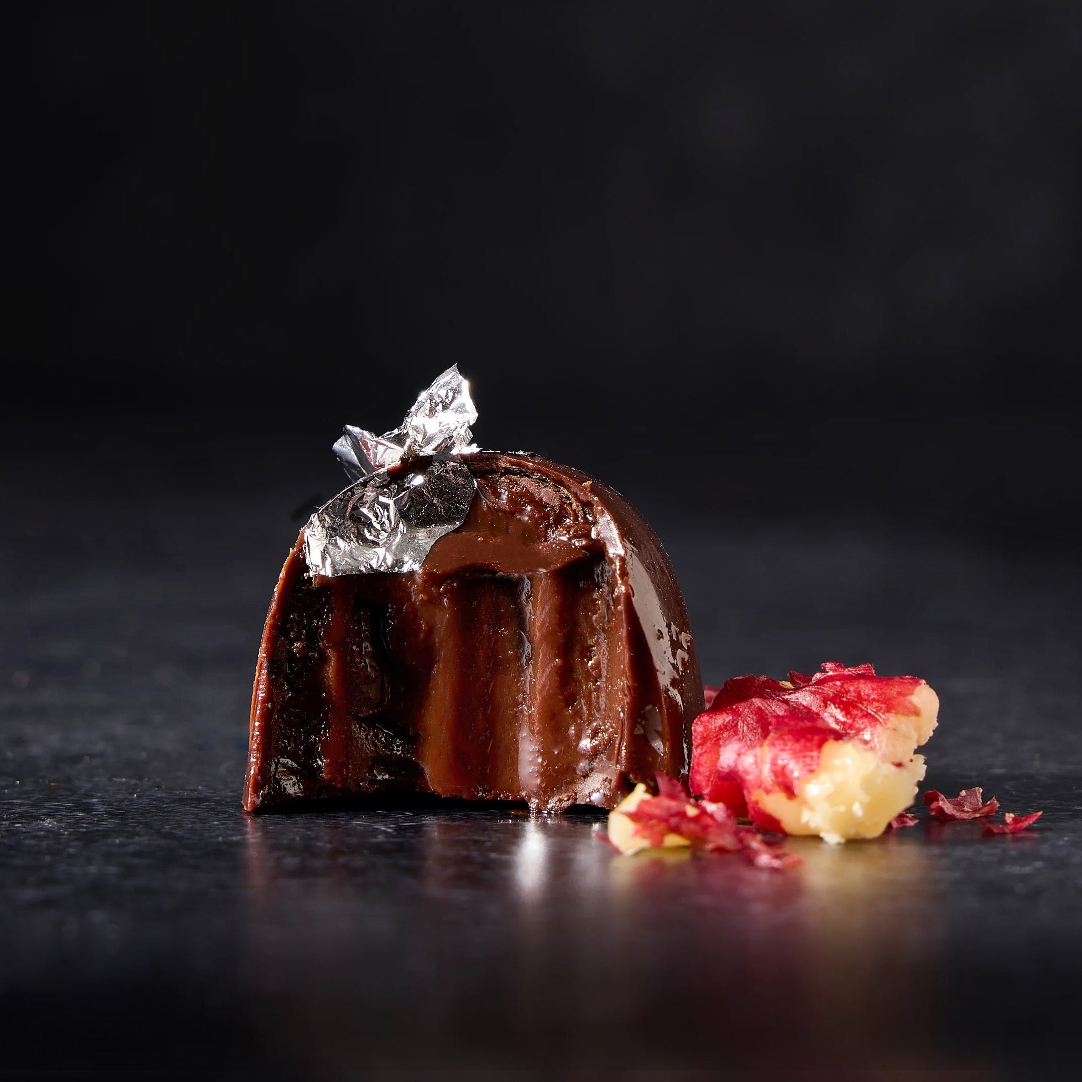 Dark Chocolate Truffle with red walnut and silver leaf.