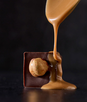 a chocolate with a nut and liquid pouring